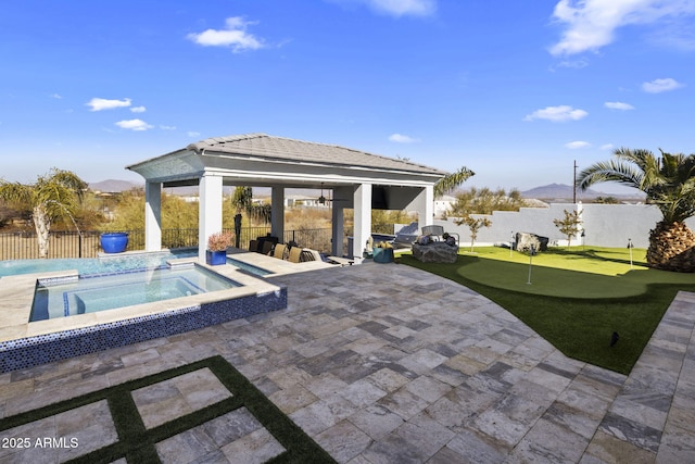 view of patio / terrace featuring an in ground hot tub, a mountain view, and a gazebo