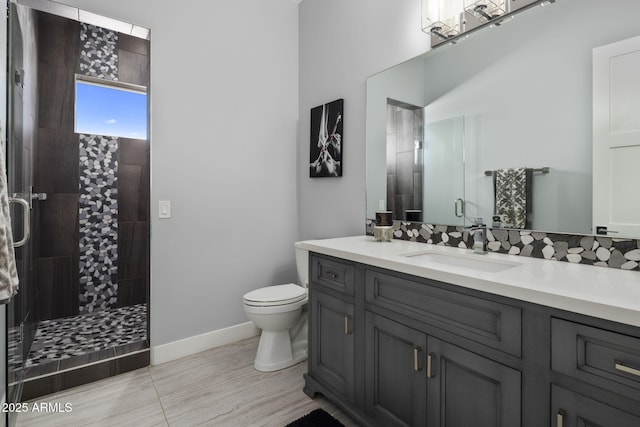 bathroom featuring vanity, a shower with shower door, and toilet