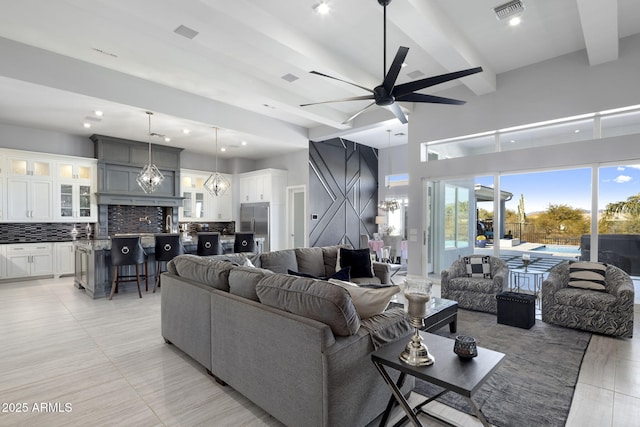 living room with ceiling fan with notable chandelier and beam ceiling