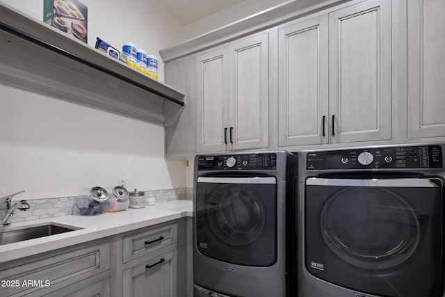 washroom featuring cabinets, separate washer and dryer, and sink