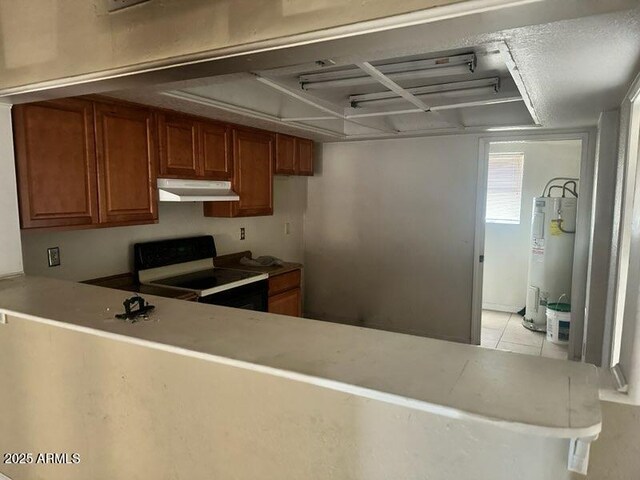 kitchen featuring light tile patterned flooring, electric water heater, and white range with gas cooktop