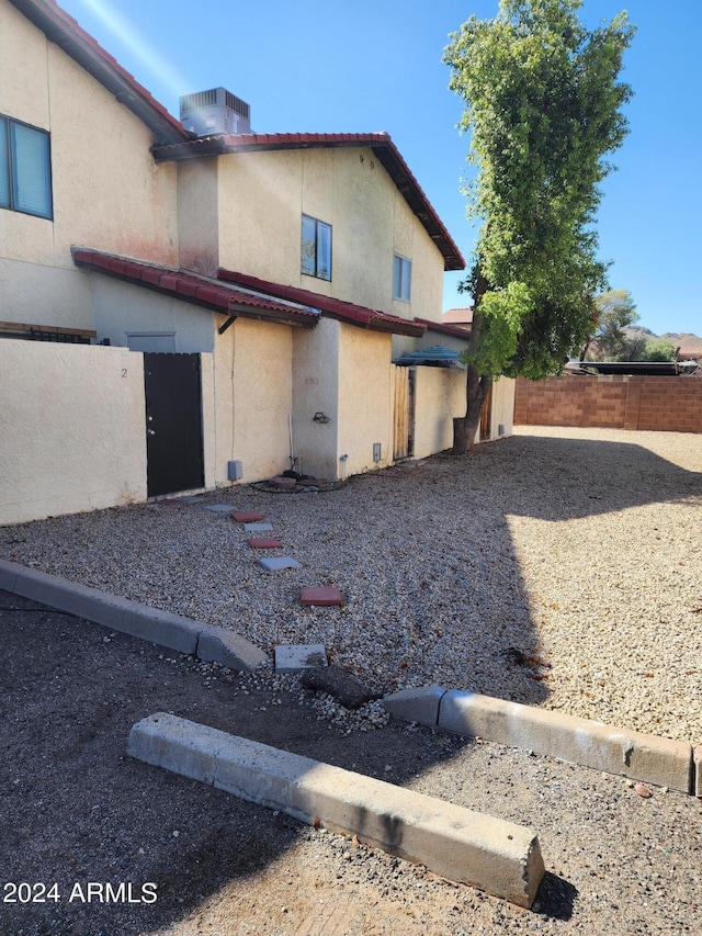 view of side of home with central air condition unit