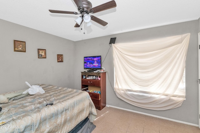 bedroom with ceiling fan and light tile patterned floors