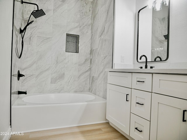 bathroom featuring vanity, tiled shower / bath combo, and wood-type flooring