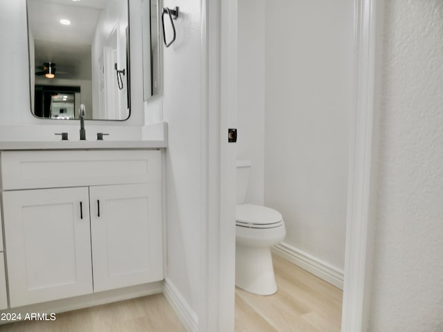 bathroom with vanity, hardwood / wood-style flooring, and toilet