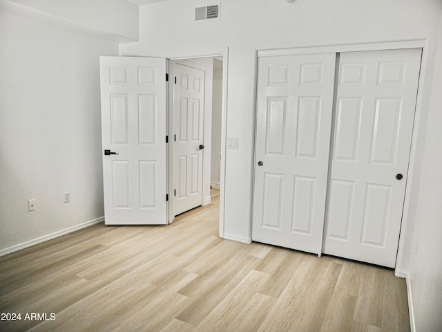 unfurnished bedroom featuring light hardwood / wood-style flooring and a closet