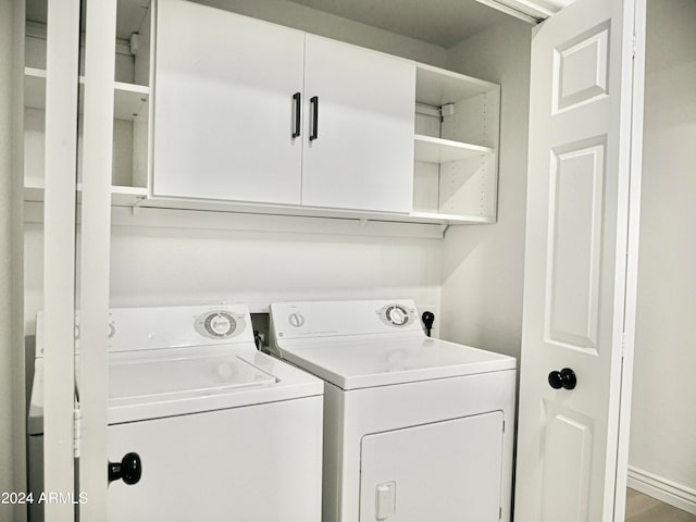 washroom with washer and dryer and cabinets