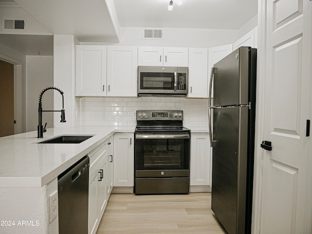 kitchen featuring sink, white cabinetry, stainless steel appliances, and light wood-type flooring