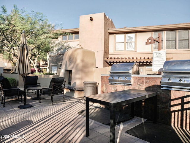 view of patio / terrace with exterior kitchen and a grill