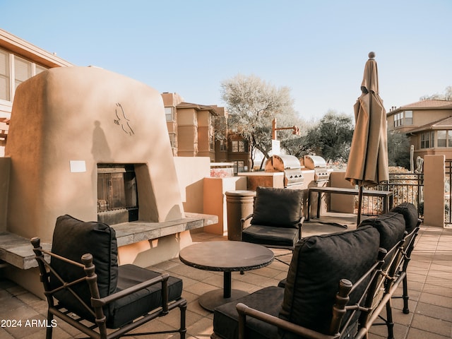 view of patio featuring an outdoor fireplace, exterior kitchen, and a grill