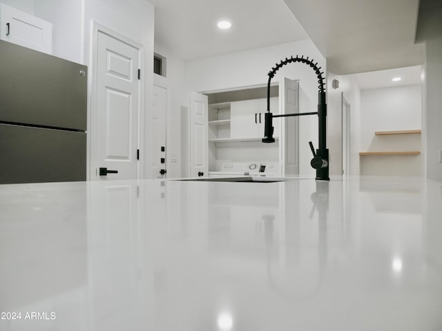 interior space with stainless steel refrigerator and white cabinets