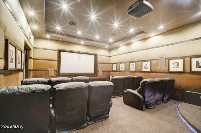 cinema room featuring wood walls and carpet