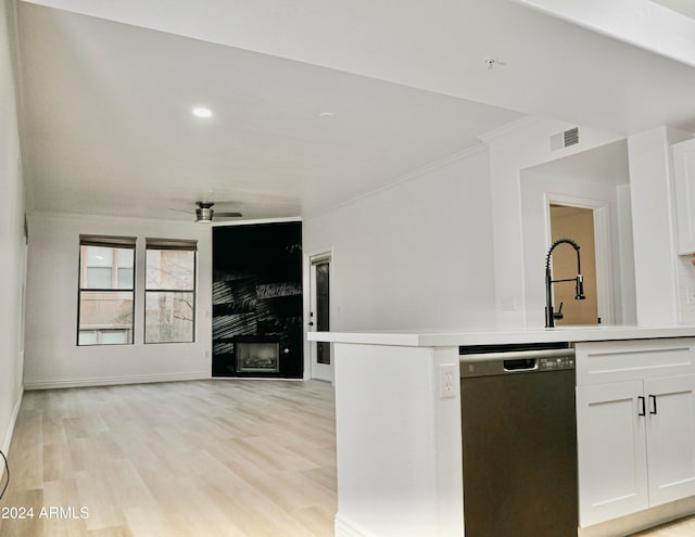 kitchen with dishwasher, light hardwood / wood-style flooring, white cabinetry, a fireplace, and ceiling fan