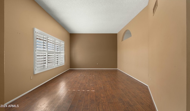 unfurnished room featuring a textured ceiling and dark hardwood / wood-style floors