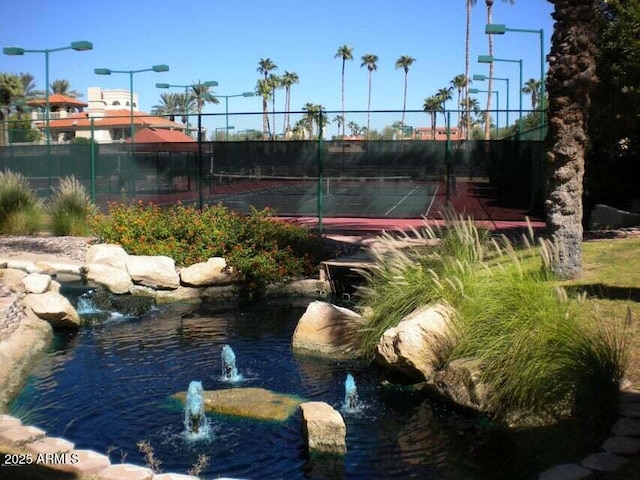 view of tennis court featuring fence