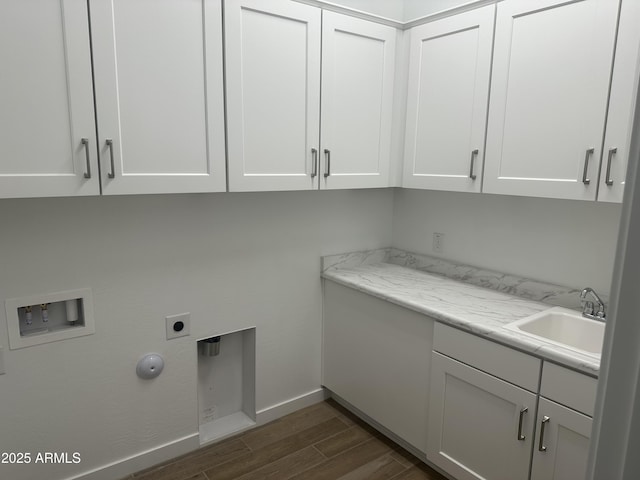 washroom featuring hookup for a washing machine, hookup for an electric dryer, cabinet space, a sink, and dark wood-type flooring