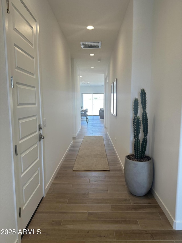 hall featuring visible vents, recessed lighting, wood finished floors, and baseboards