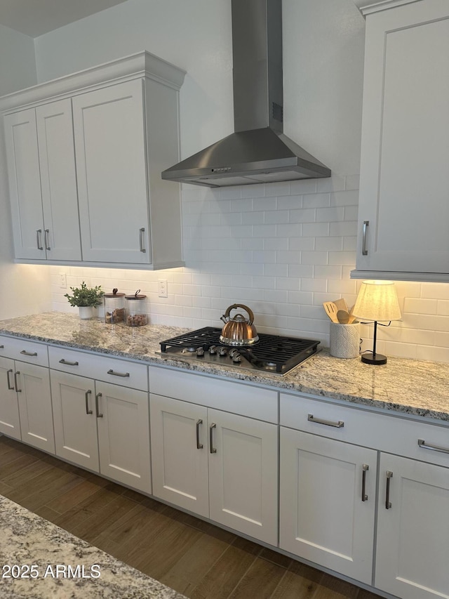 kitchen featuring wall chimney range hood, dark wood-style floors, and tasteful backsplash