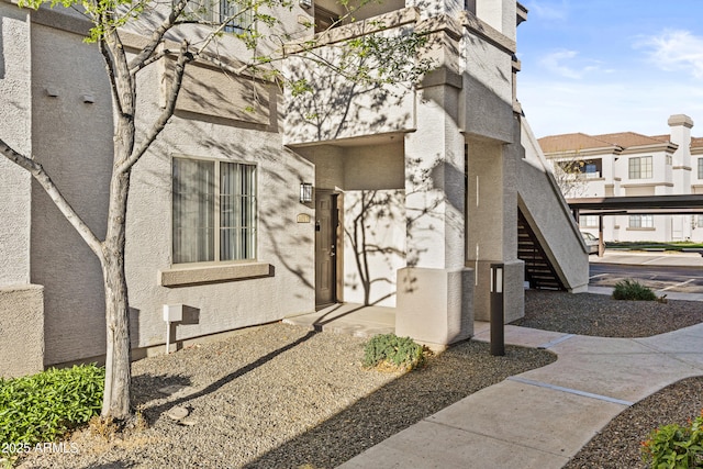 view of property exterior featuring stairs and stucco siding