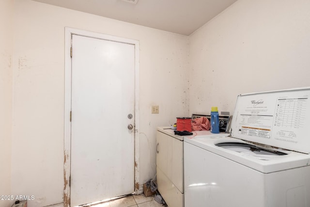 washroom featuring laundry area, light tile patterned floors, and washing machine and clothes dryer