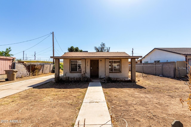 view of front of home featuring fence and stucco siding