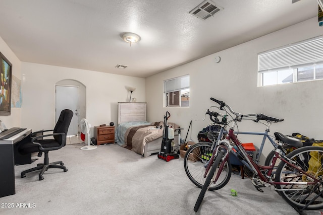 carpeted bedroom with arched walkways and visible vents