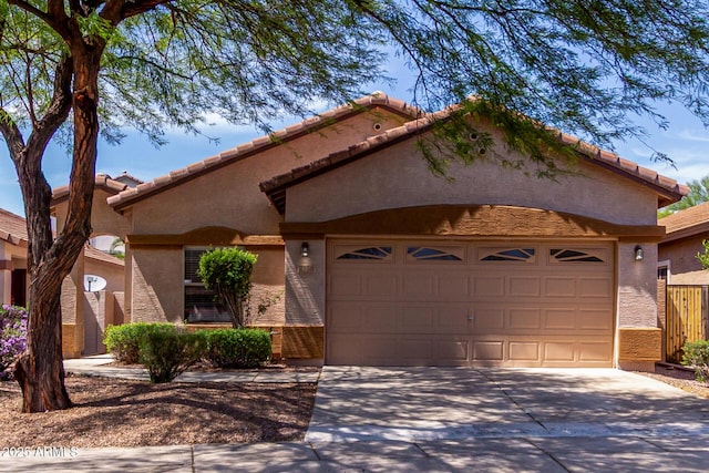 2556 W Amber Sun Dr, Phoenix, AZ 85085 - mediterranean / spanish house with an attached garage, concrete driveway, stucco siding, and a tiled roof