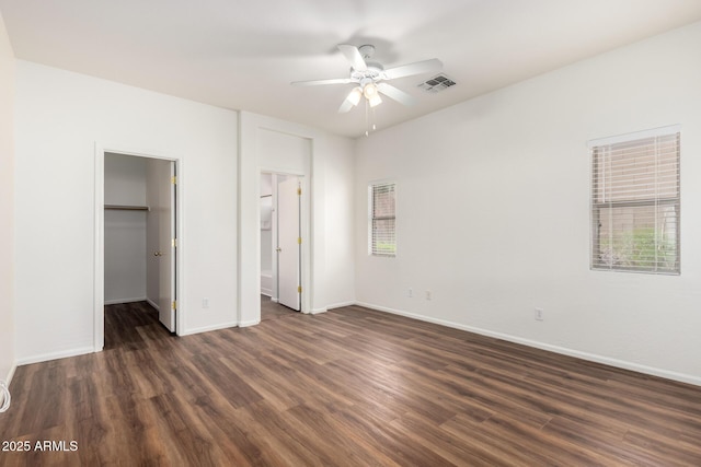 2556 W Amber Sun Dr, Phoenix, AZ 85085 - unfurnished bedroom with dark wood-type flooring, a spacious closet, and multiple windows
