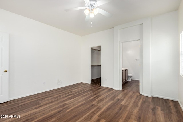 2556 W Amber Sun Dr, Phoenix, AZ 85085 - unfurnished bedroom featuring dark wood-style flooring, a closet, ensuite bathroom, a walk in closet, and a ceiling fan