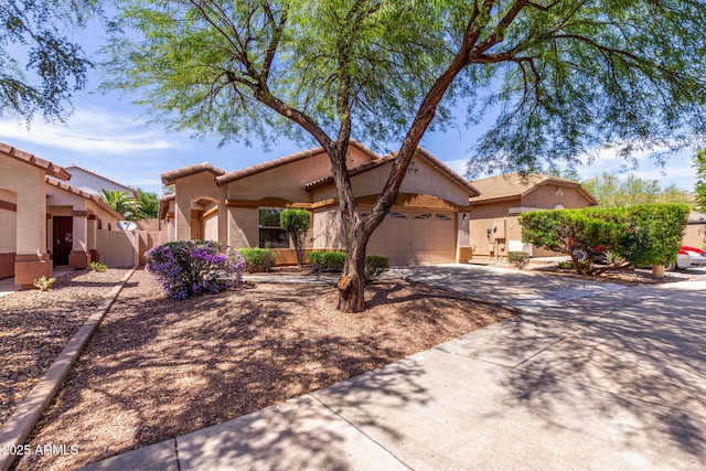 2556 W Amber Sun Dr, Phoenix, AZ 85085 - mediterranean / spanish house featuring concrete driveway, stucco siding, an attached garage, and a tiled roof