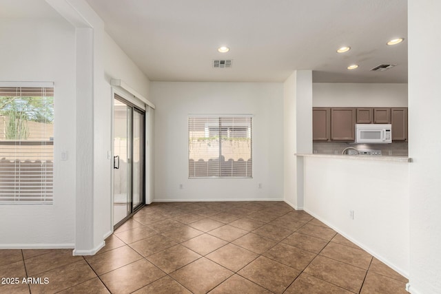 2556 W Amber Sun Dr, Phoenix, AZ 85085 - unfurnished living room with plenty of natural light, recessed lighting, and tile patterned flooring