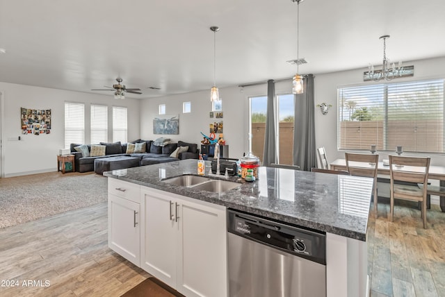 kitchen featuring pendant lighting, stainless steel dishwasher, sink, and white cabinets