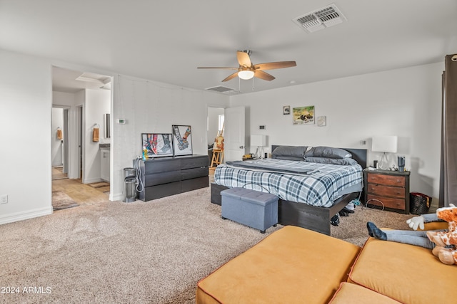 bedroom with light carpet, connected bathroom, and ceiling fan