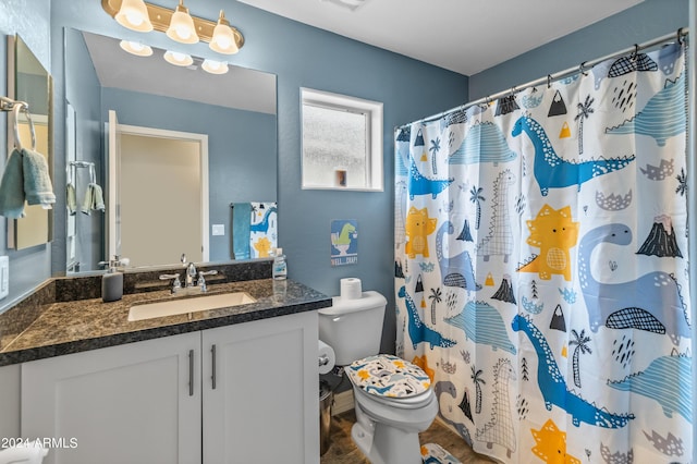 bathroom with vanity, curtained shower, and toilet