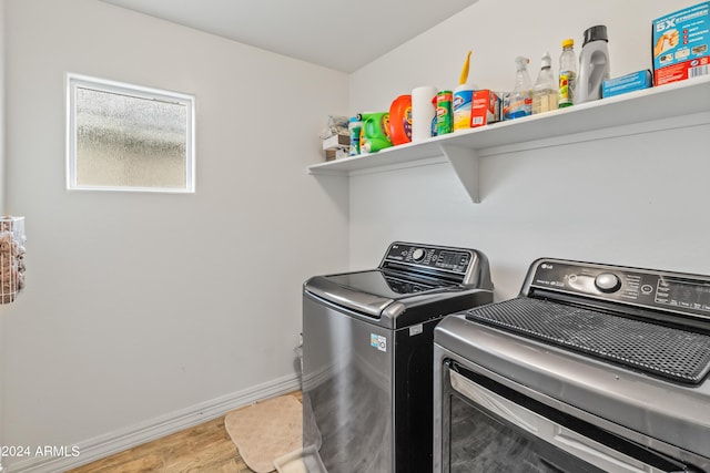 laundry area featuring washer and clothes dryer and light wood-type flooring