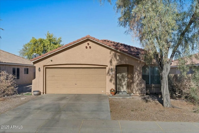 mediterranean / spanish-style home featuring a garage, a tiled roof, driveway, and stucco siding