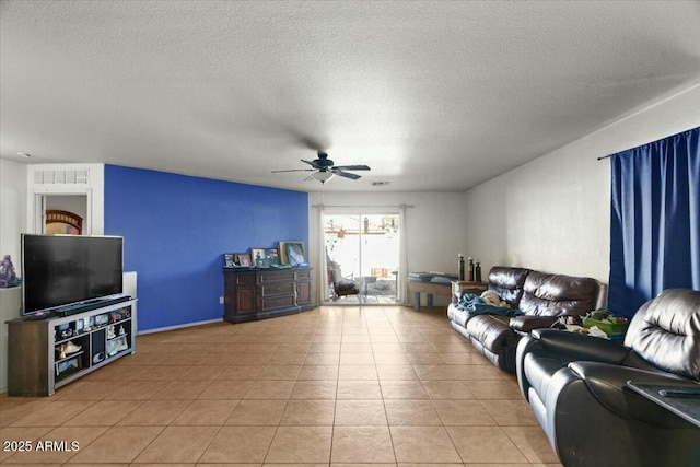 living room with a ceiling fan, a textured ceiling, visible vents, and light tile patterned flooring