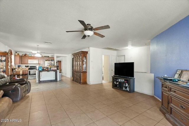 living room with visible vents, a ceiling fan, a textured ceiling, and light tile patterned floors
