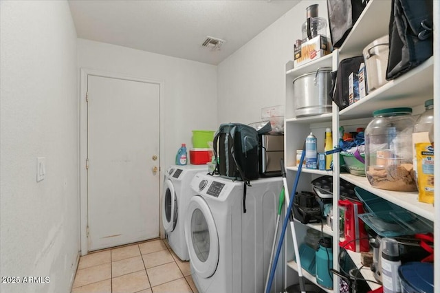 laundry room with laundry area, light tile patterned floors, visible vents, and washing machine and clothes dryer