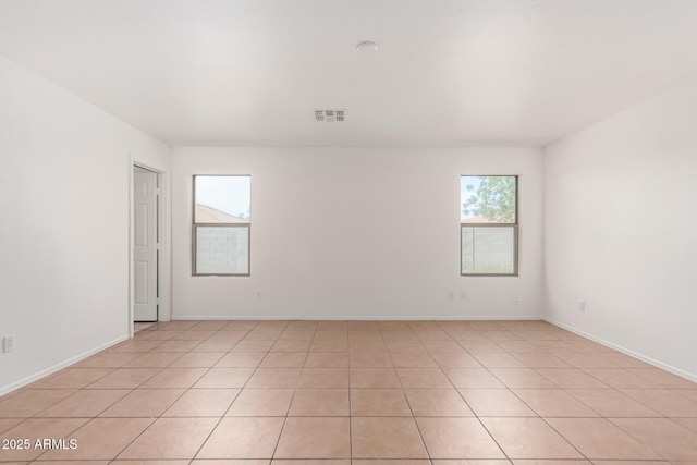 spare room with baseboards, visible vents, and light tile patterned floors