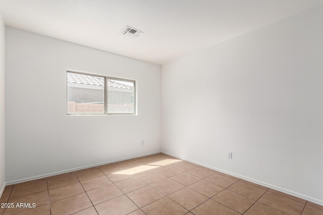 spare room featuring baseboards, visible vents, and light tile patterned floors