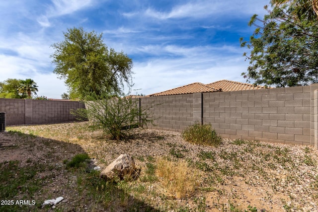 view of yard with a fenced backyard and central AC
