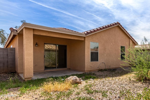back of property with a patio, stucco siding, and a tiled roof
