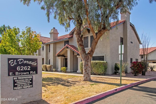 exterior space featuring a tiled roof, a chimney, and stucco siding