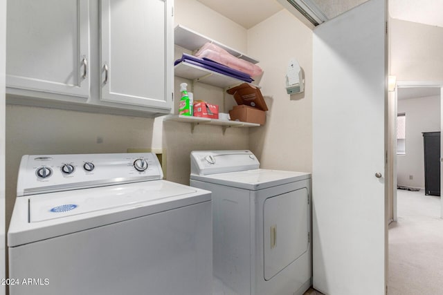 laundry room with light colored carpet, cabinet space, and washer and clothes dryer