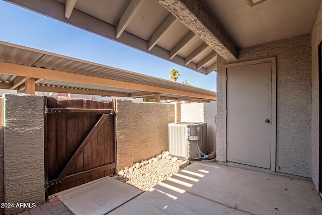 view of patio featuring a gate, fence, and cooling unit