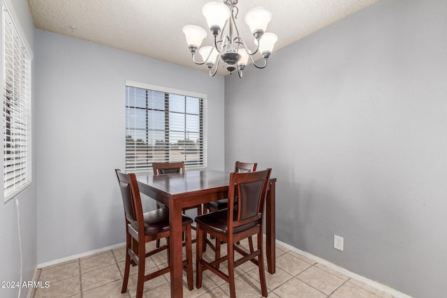 dining area featuring light tile patterned floors, baseboards, and a notable chandelier