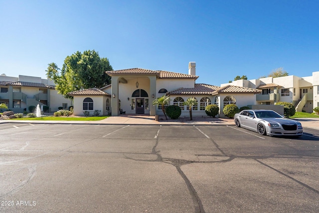 1825 W Ray Rd Unit 1068, Chandler, AZ 85224 - mediterranean / spanish house with a tiled roof, a chimney, uncovered parking, a residential view, and stucco siding