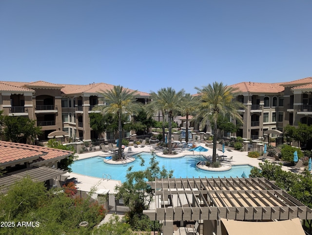 community pool with a patio area and fence