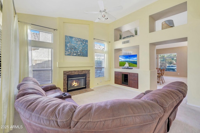 living area featuring light carpet, a fireplace, and a high ceiling